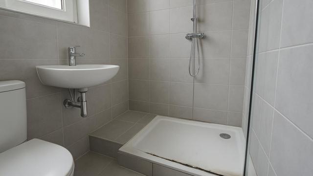 Łazienka po remoncie z pleśnią na silikonie i kałużą przy odpływie
