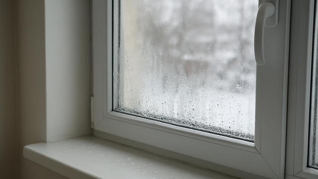Zaparowana szyba okna PCV od wewnątrz z kroplami wody na dole